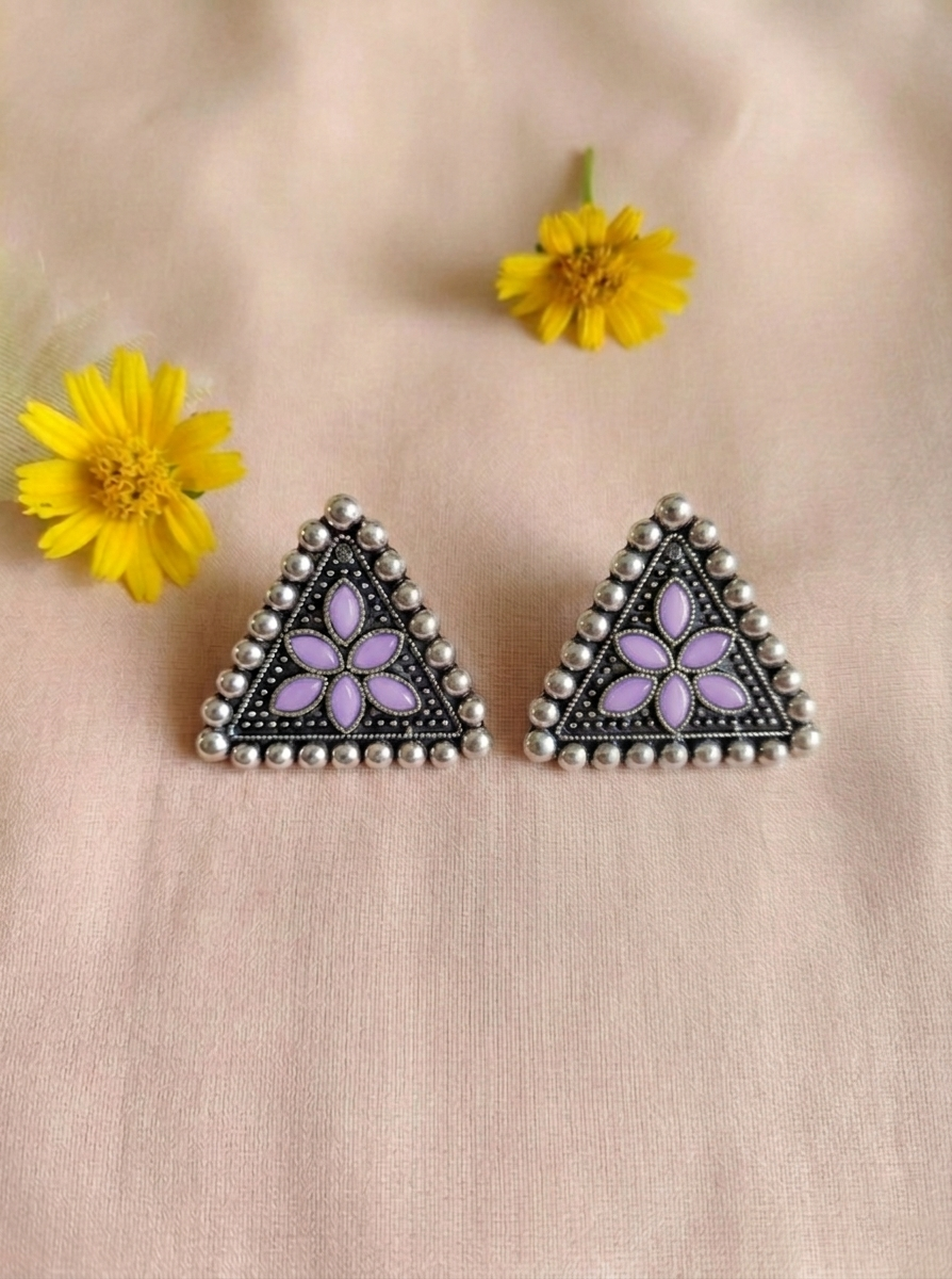 Close-up of Isitaara oxidized silver triangular sitar floral stud earrings with purple floral detailing and intricate handcrafted beadwork.