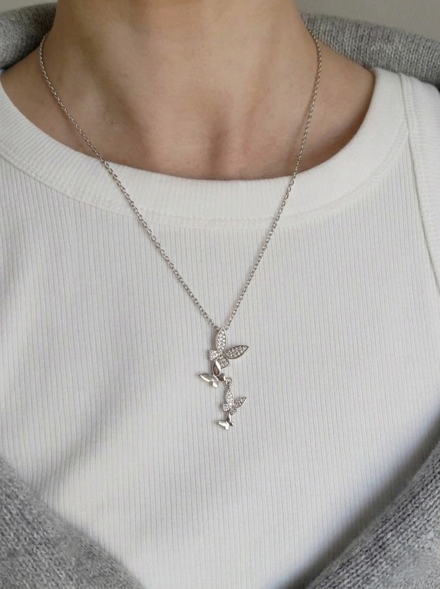 Model wearing Mariposa Butterfly Pendant Necklace silver chain with butterfly pendant styled over white top