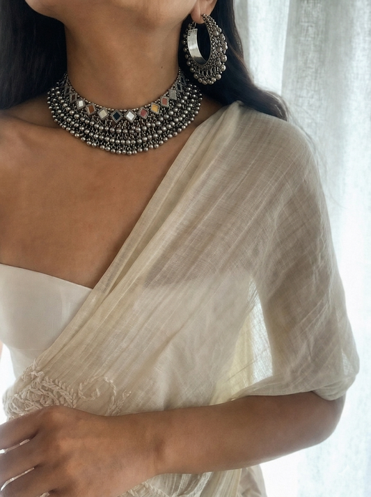 Model wearing Meera Ghungroo Choker Set with oxidized silver necklace and hoop earrings styled with white saree