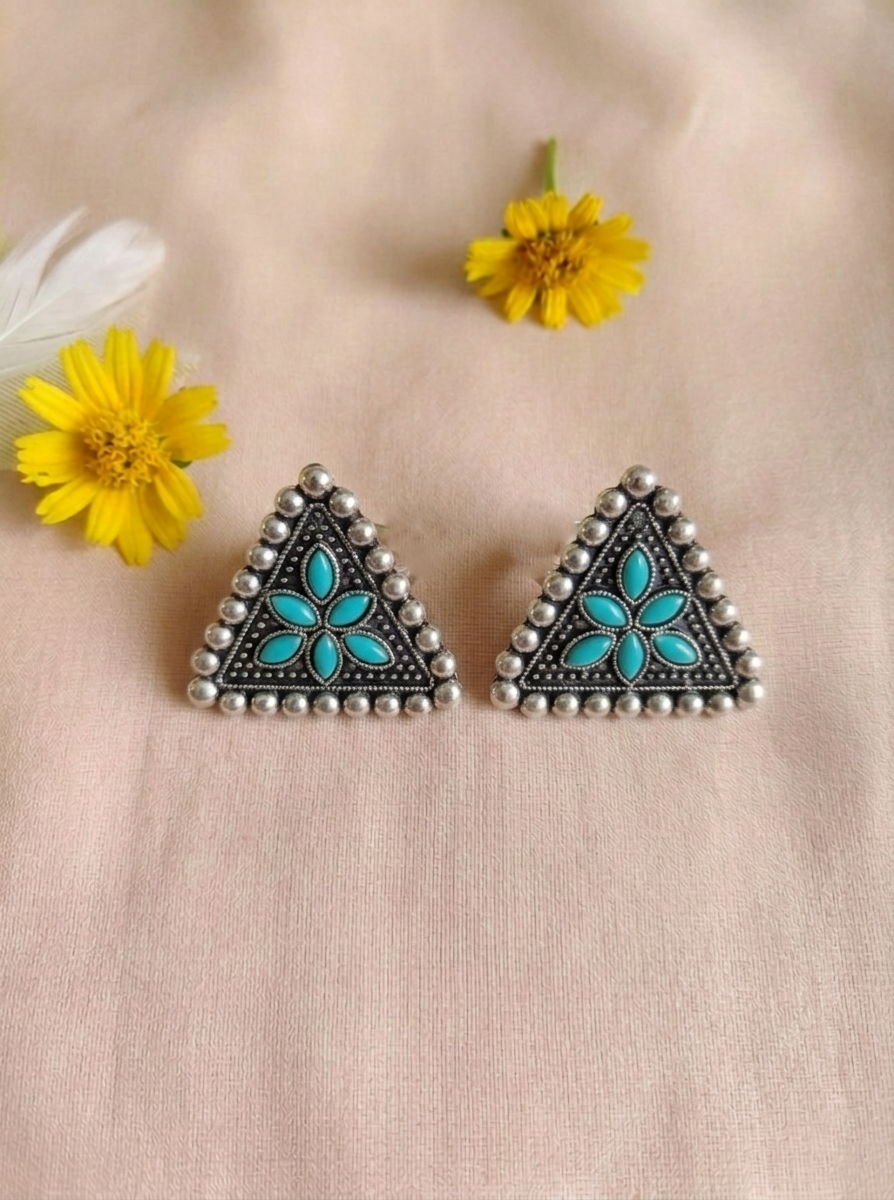 Close-up of Isitaara oxidized silver triangular sitar floral stud earrings with blue floral detailing and intricate handcrafted beadwork.