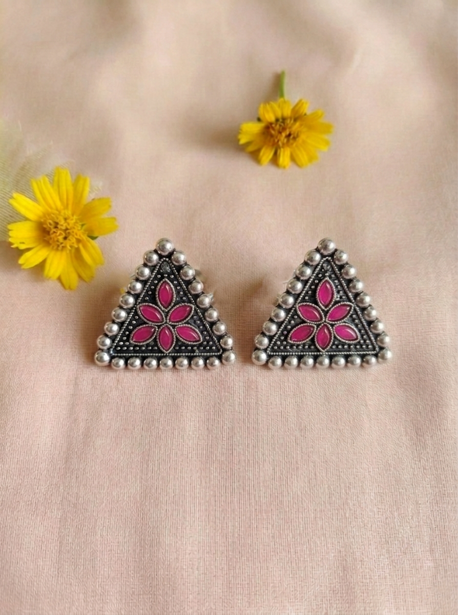 Close-up of Isitaara oxidized silver triangular sitar floral stud earrings with pink floral detailing and intricate handcrafted beadwork.